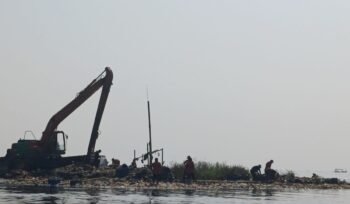 Petugas Dinas Lingkungan Hidup membersihkan tumpukan sampah di Muara Angke, Jakarta Utara, yang masih tersisa meskipun sudah mengecil